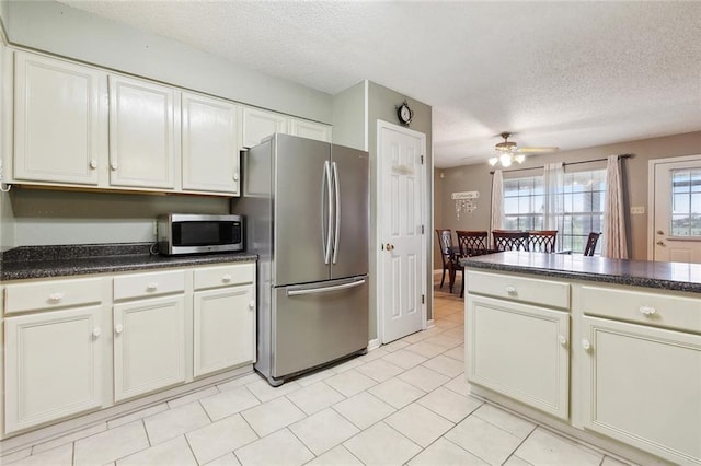 7045 River Rd, Waggaman, LA 70094 - kitchen with stainless steel appliances, a textured ceiling, dark countertops, ceiling fan, and light tile patterned floors