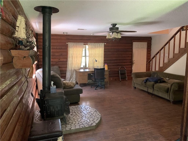26203 Dove St, Ponchatoula, LA 70454 - living area with a wood stove, rustic walls, wood-type flooring, ceiling fan, and stairs