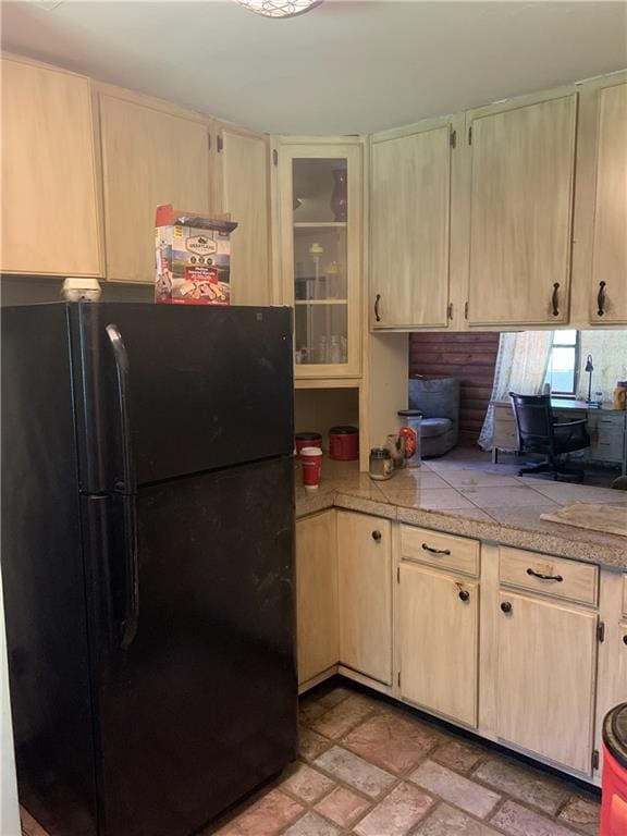26203 Dove St, Ponchatoula, LA 70454 - kitchen with freestanding refrigerator, light brown cabinetry, glass insert cabinets, and tile countertops