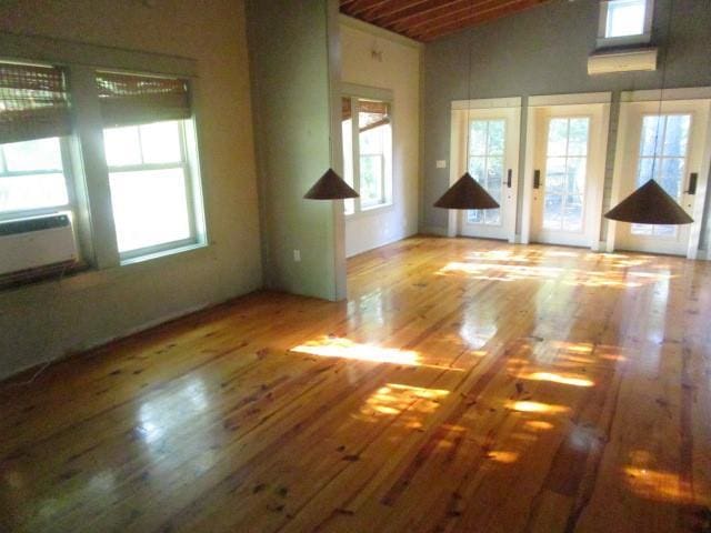 6561 Catina St, New Orleans, LA 70124 - spare room featuring healthy amount of natural light, wood finished floors, high vaulted ceiling, and cooling unit