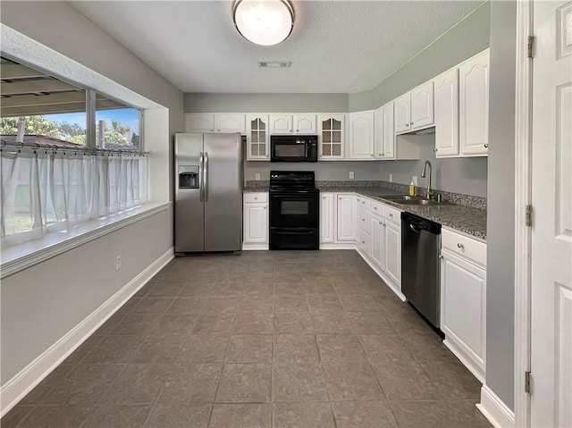 128 Hollowrock Ct, Slidell, LA 70461 - kitchen with black appliances, a sink, glass insert cabinets, white cabinetry, and dark stone countertops
