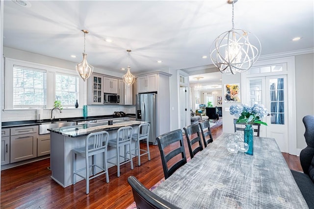 2134 Harmony St, New Orleans, LA 70115 - dining space with a chandelier, recessed lighting, dark wood-style floors, and ornamental molding