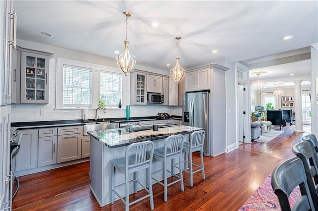 2134 Harmony St, New Orleans, LA 70115 - kitchen featuring appliances with stainless steel finishes, gray cabinets, a sink, a chandelier, and decorative backsplash