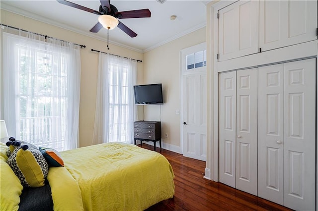 2134 Harmony St, New Orleans, LA 70115 - bedroom with dark wood finished floors, ornamental molding, baseboards, ceiling fan, and a closet