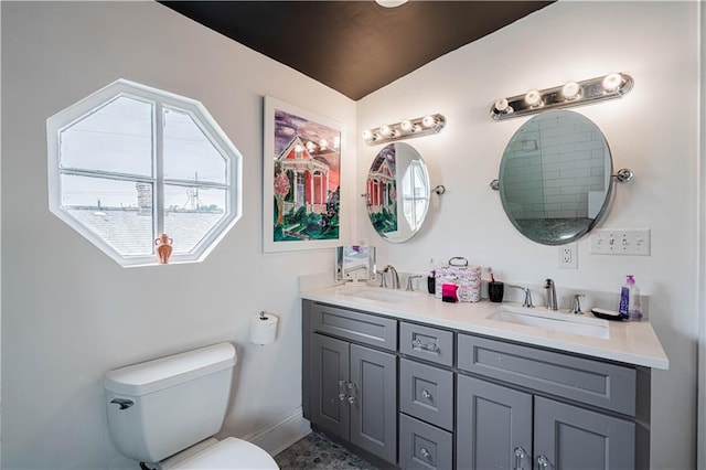 2134 Harmony St, New Orleans, LA 70115 - bathroom featuring double vanity, toilet, and baseboards