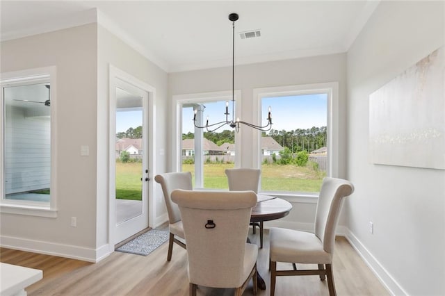 72665 Robindale Dr, Covington, LA 70434 - dining space with light wood-style flooring, a chandelier, baseboards, and ornamental molding