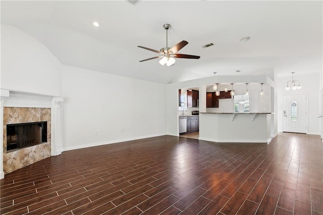 121 Gail Dr, La Place, LA 70068 - unfurnished living room with lofted ceiling, ceiling fan, a chandelier, dark wood finished floors, and a tile fireplace