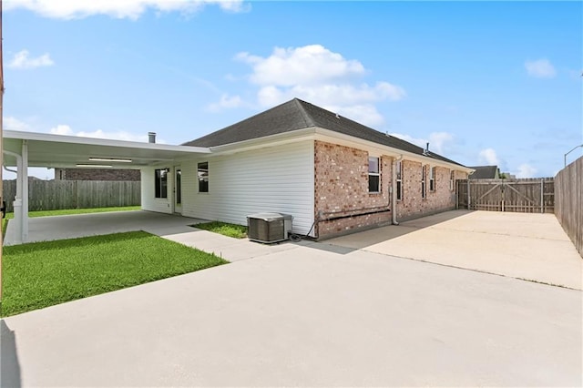 121 Gail Dr, La Place, LA 70068 - back of property featuring brick siding, central AC unit, a patio area, and a gate