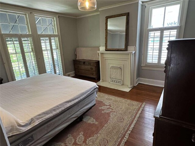 1228 Pine St, New Orleans, LA 70118 - bedroom with ornamental molding, baseboards, dark wood-style flooring, a fireplace with flush hearth, and access to exterior
