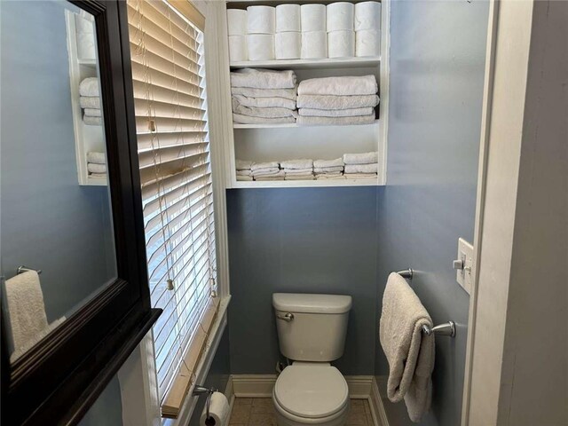 1228 Pine St, New Orleans, LA 70118 - bathroom featuring toilet, baseboards, and tile patterned floors