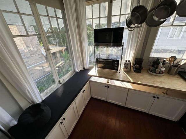 1228 Pine St, New Orleans, LA 70118 - kitchen with dark wood-style flooring, white cabinetry, and light countertops