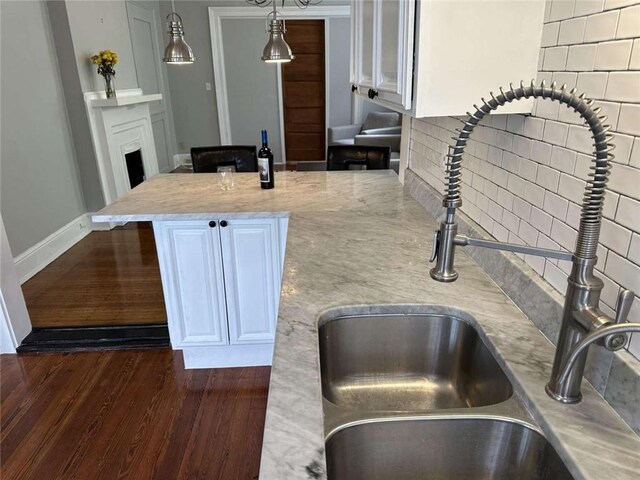 1228 Pine St, New Orleans, LA 70118 - kitchen with a sink, decorative backsplash, light stone countertops, dark wood-style flooring, and decorative light fixtures