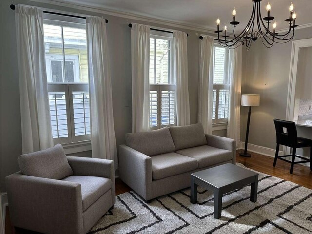 1228 Pine St, New Orleans, LA 70118 - living room featuring a chandelier, crown molding, baseboards, and wood finished floors