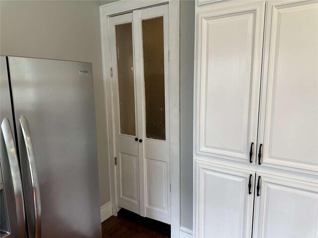 1228 Pine St, New Orleans, LA 70118 - detailed view of stainless steel refrigerator with ice dispenser, wood finished floors, and baseboards