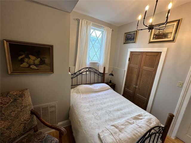 1228 Pine St, New Orleans, LA 70118 - bedroom with a chandelier, baseboards, and wood finished floors