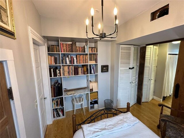1228 Pine St, New Orleans, LA 70118 - bedroom with a chandelier and wood finished floors