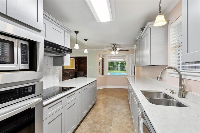 335 Devon Rd, La Place, LA 70068 - kitchen featuring stainless steel appliances, a sink, backsplash, decorative light fixtures, and light tile patterned floors