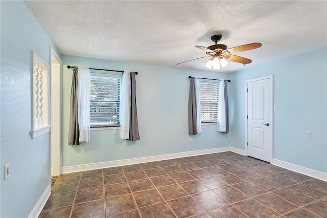 335 Devon Rd, La Place, LA 70068 - unfurnished room with a textured ceiling, ceiling fan, dark tile patterned flooring, and baseboards
