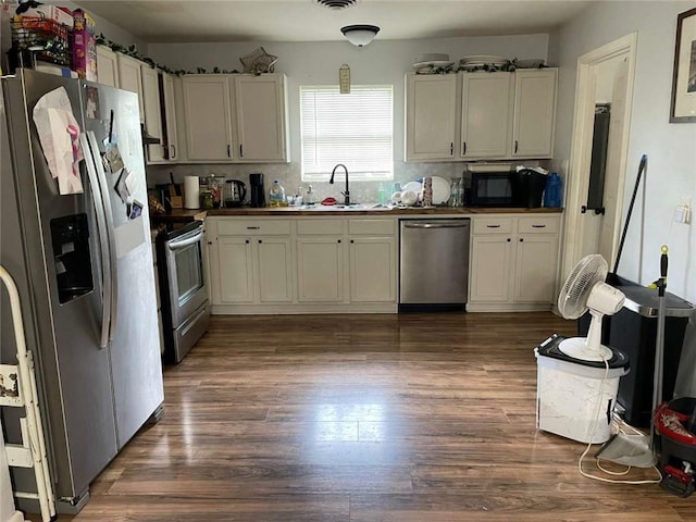 1127 Cousin St, Slidell, LA 70458 - kitchen featuring appliances with stainless steel finishes, a sink, dark wood-type flooring, and dark countertops