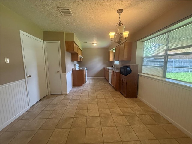 106 Leonell Cir, Slidell, LA 70458 - kitchen with a chandelier, a textured ceiling, a sink, light tile patterned floors, and white appliances