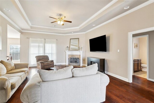 410 Lakewood Dr, Luling, LA 70070 - living area with a tray ceiling, a ceiling fan, dark wood-style floors, baseboards, and ornamental molding