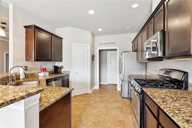 410 Lakewood Dr, Luling, LA 70070 - kitchen with stainless steel appliances, a sink, light stone countertops, dark brown cabinetry, and light tile patterned flooring