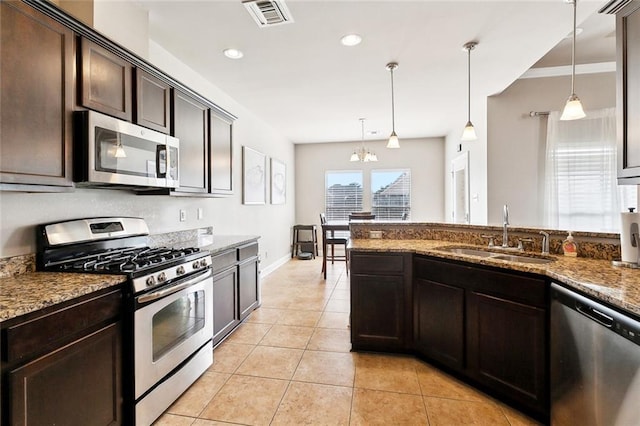 410 Lakewood Dr, Luling, LA 70070 - kitchen with appliances with stainless steel finishes, a sink, dark brown cabinets, stone countertops, and light tile patterned floors