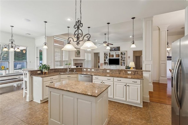229 Pine Crest Dr, Madisonville, LA 70447 - kitchen with appliances with stainless steel finishes, a spacious island, a ceiling fan, ornamental molding, and a sink