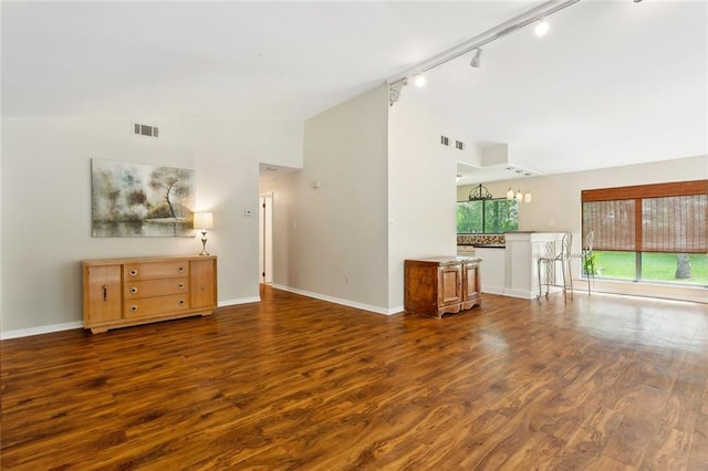 71152 Cutter Pl, Abita Springs, LA 70420 - unfurnished living room with track lighting, wood finished floors, baseboards, and high vaulted ceiling