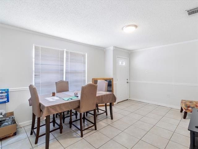 340103 Frenchmen St, New Orleans, LA 70122 - dining space with a textured ceiling, healthy amount of natural light, crown molding, and light tile patterned flooring