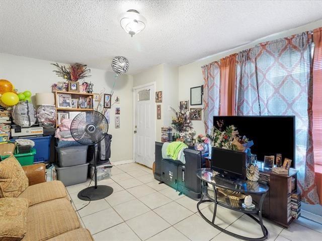 340103 Frenchmen St, New Orleans, LA 70122 - living area featuring light tile patterned floors and a textured ceiling