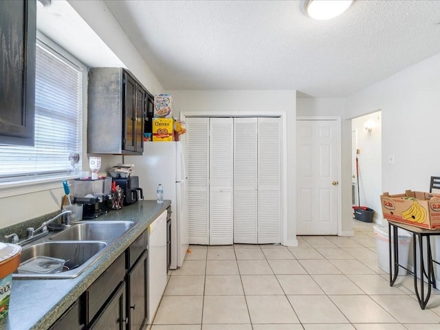 340103 Frenchmen St, New Orleans, LA 70122 - kitchen featuring a sink, white appliances, a textured ceiling, dark countertops, and dark brown cabinetry
