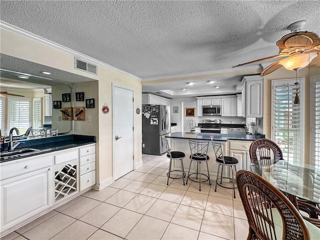 177 Moonraker Dr, Slidell, LA 70458 - kitchen with appliances with stainless steel finishes, a sink, ornamental molding, dark countertops, and a textured ceiling