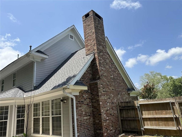 108 Riverbirch Dr, Lafayette, LA 70508 - view of home's exterior with roof with shingles, brick siding, and a chimney