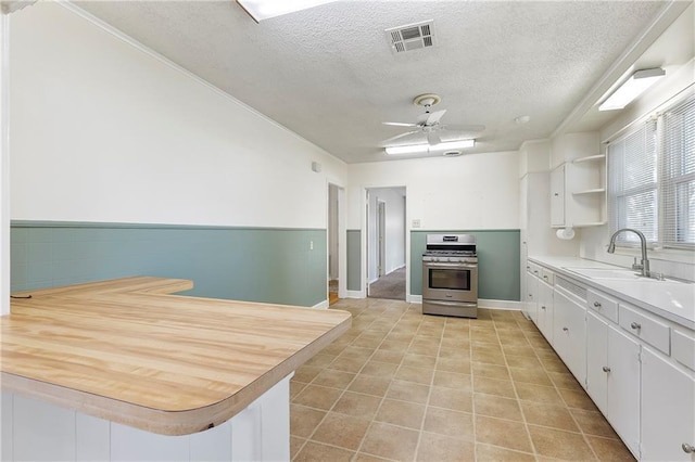 501 Gaudet Dr, Marrero, LA 70072 - kitchen featuring stainless steel gas stove, a sink, a textured ceiling, white cabinets, and light countertops