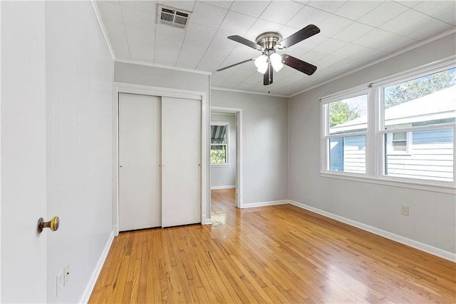 501 Gaudet Dr, Marrero, LA 70072 - unfurnished bedroom with ornamental molding, light wood-style flooring, a closet, baseboards, and ceiling fan