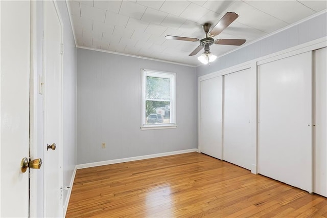 501 Gaudet Dr, Marrero, LA 70072 - unfurnished bedroom with crown molding, two closets, light wood-style floors, baseboards, and ceiling fan