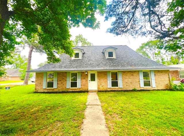 26192 Fallen Oaks Dr, Denham Springs, LA 70726 - cape cod-style house featuring brick siding, a front lawn, and roof with shingles