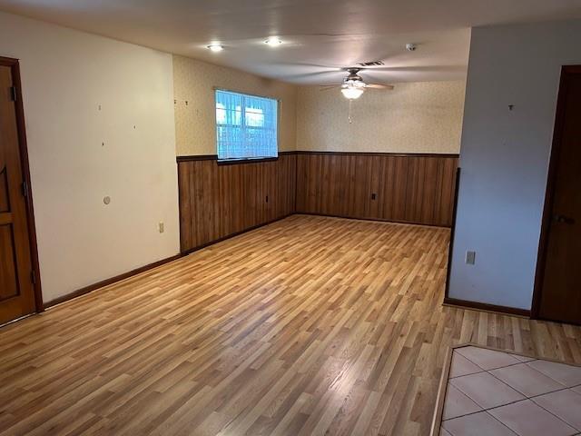 523 Beverly Garden Dr, Metairie, LA 70001 - unfurnished room with wainscoting, a ceiling fan, light wood-type flooring, and wooden walls
