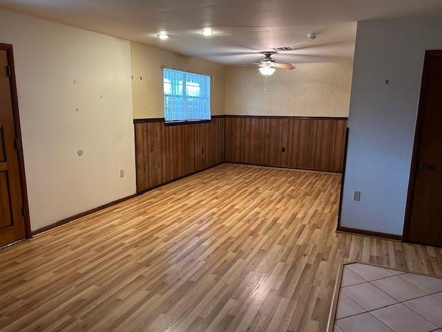523 Beverly Garden Dr, Metairie, LA 70001 - spare room featuring a wainscoted wall, light wood-style floors, ceiling fan, and wood walls