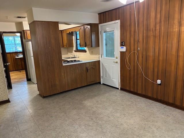 523 Beverly Garden Dr, Metairie, LA 70001 - kitchen with light countertops, wooden walls, ceiling fan, and freestanding refrigerator