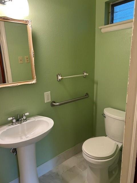 523 Beverly Garden Dr, Metairie, LA 70001 - half bathroom featuring marble finish floors, baseboards, and toilet