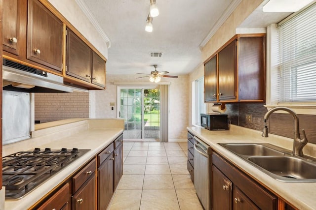 1400 Velma St, Metairie, LA 70001 - kitchen featuring appliances with stainless steel finishes, under cabinet range hood, a sink, backsplash, and light countertops