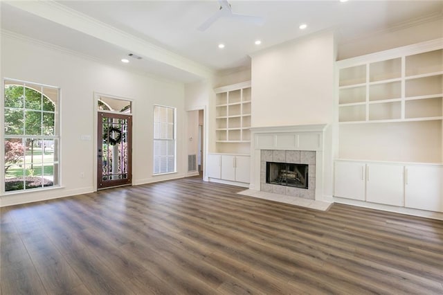 2308 Crossing Ct, Mandeville, LA 70448 - unfurnished living room featuring a ceiling fan, crown molding, dark wood-style flooring, a tiled fireplace, and recessed lighting