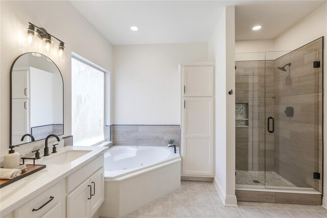 2308 Crossing Ct, Mandeville, LA 70448 - full bath featuring vanity, a tub with jets, a shower stall, tile patterned flooring, and baseboards