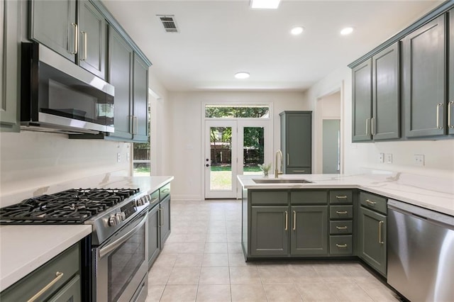 2308 Crossing Ct, Mandeville, LA 70448 - kitchen featuring stainless steel appliances, a sink, a peninsula, recessed lighting, and light tile patterned flooring