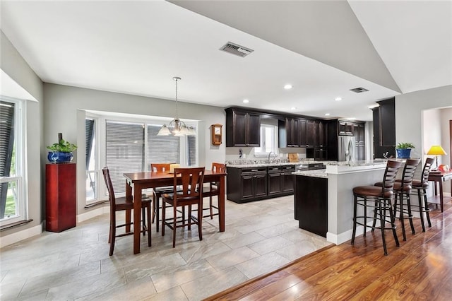 4321 San Remo Rd, New Orleans, LA 70129 - kitchen featuring stainless steel fridge with ice dispenser, a breakfast bar, a chandelier, a peninsula, and decorative light fixtures