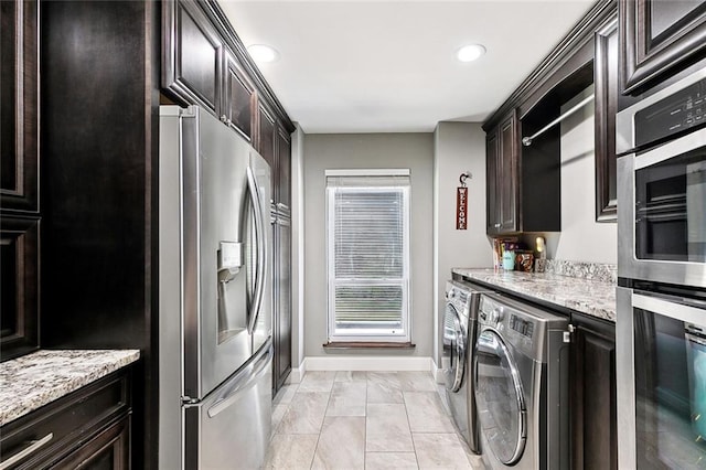 4321 San Remo Rd, New Orleans, LA 70129 - kitchen featuring appliances with stainless steel finishes, washer and clothes dryer, baseboards, light stone counters, and recessed lighting