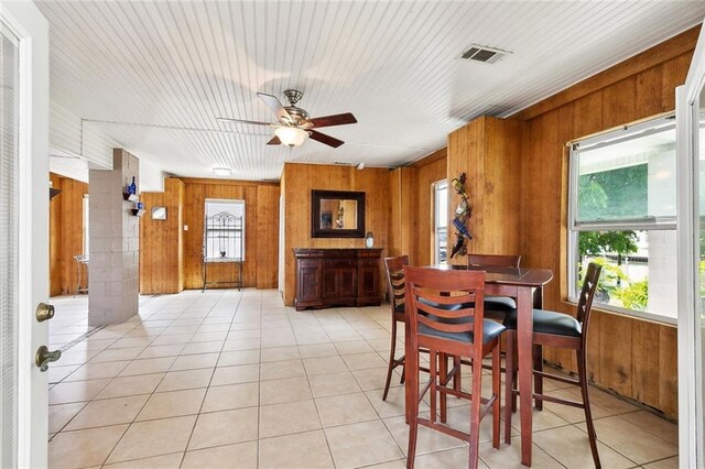 4321 San Remo Rd, New Orleans, LA 70129 - dining space featuring wooden walls, a ceiling fan, and light tile patterned flooring