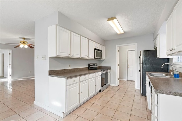 206 Chubasco Ln, Slidell, LA 70458 - kitchen featuring stainless steel appliances, dark countertops, light tile patterned flooring, white cabinetry, and a textured ceiling